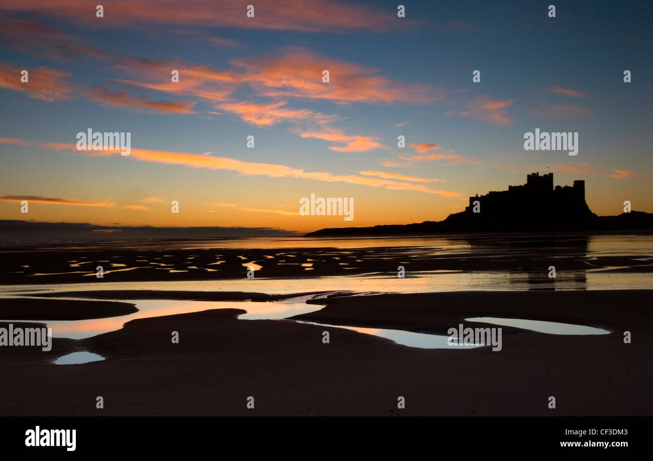 Un stagliano vista del castello di Bamburgh all'alba. Il castello è seduto su un affioramento di basalto sul bordo del mare del Nord a un Bamburgh Foto Stock