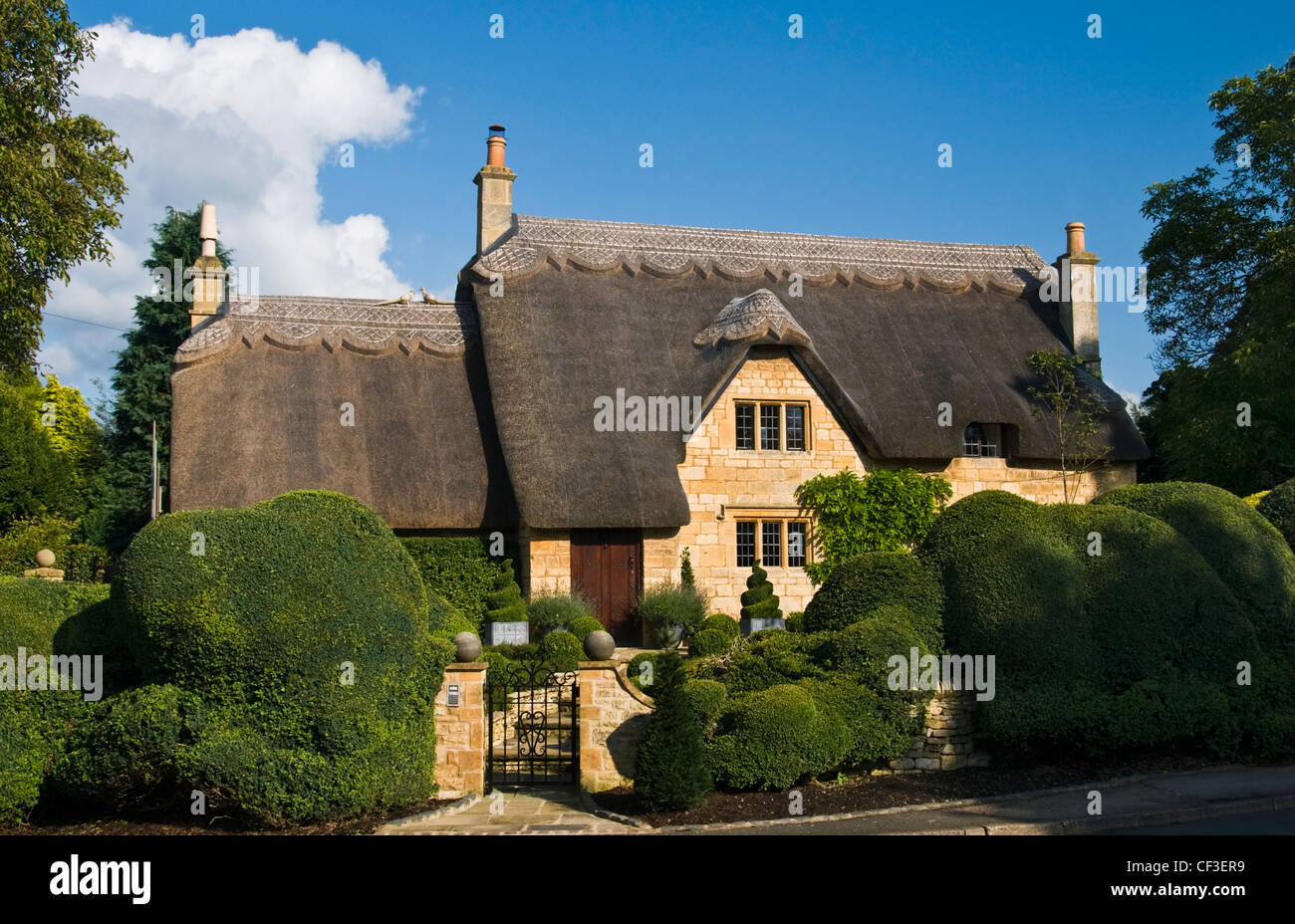 Siepi circondano un tradizionale cottage con il tetto di paglia a Chipping Camden, nel Gloucestershire. Foto Stock