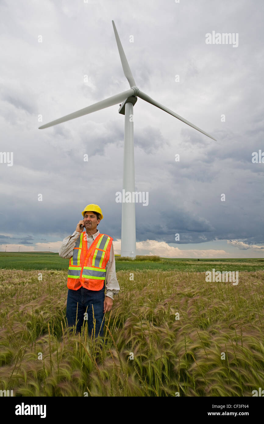 Il potere di vento tecnico in piedi accanto a turbina eolica, in prossimità del rullo di estrazione Creek, Alberta. Foto Stock