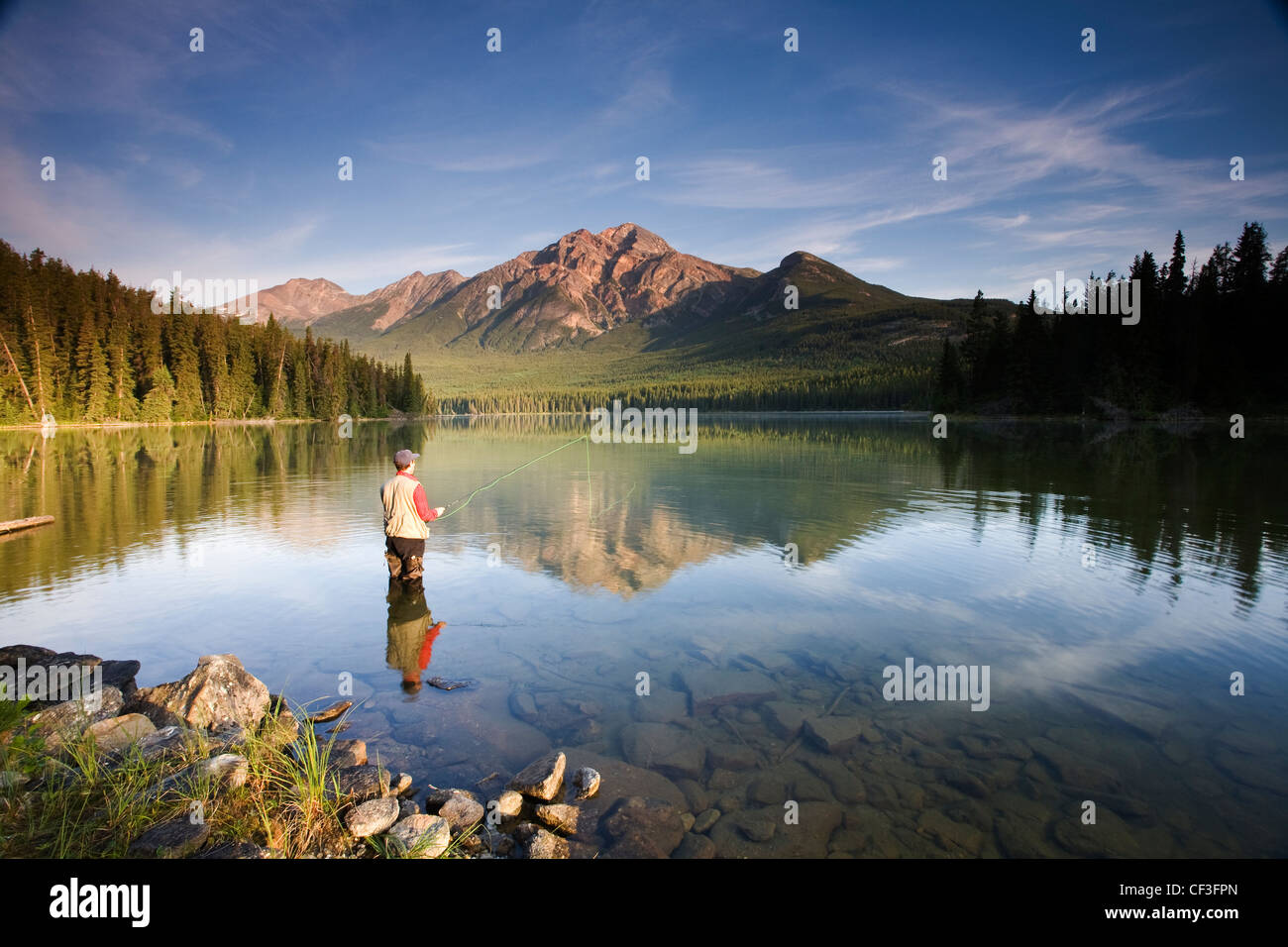 Medio maschile in età di Pesca a Mosca Report di Pesca in Lago Piramide, il Parco Nazionale di Jasper, Alberta, Canada. Foto Stock