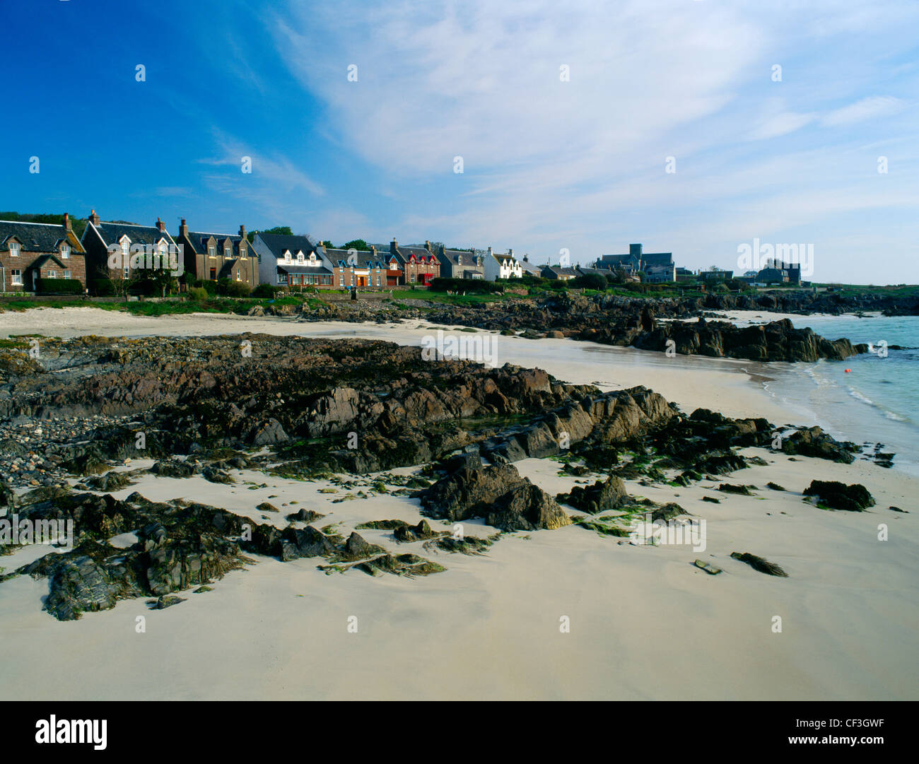 Una vista lungo la riva di San Ronan's Bay dal molo a Baile Mor, mostrando il villaggio principale strada con l' abbazia di là. Foto Stock