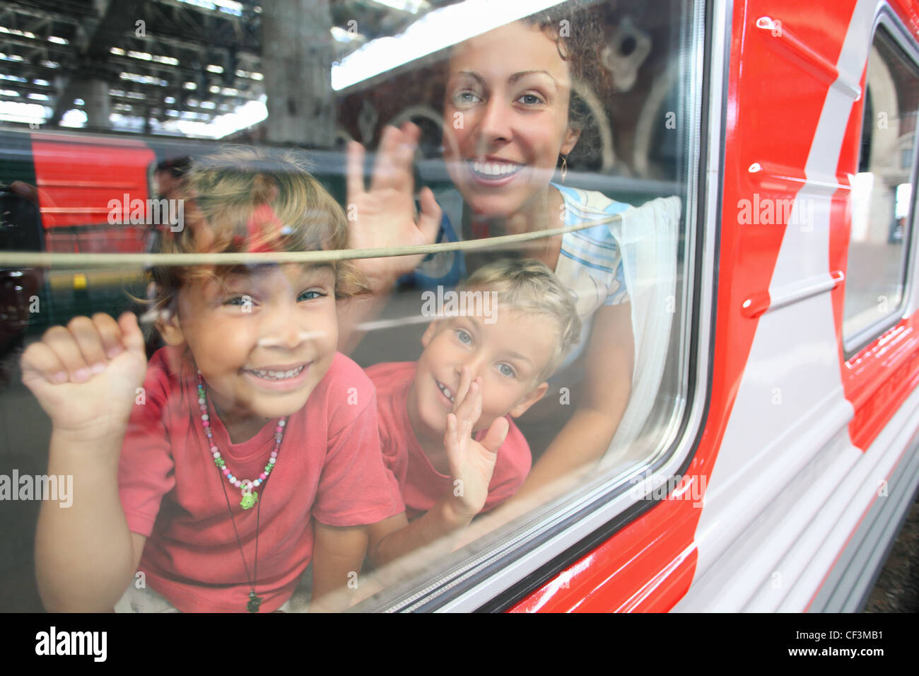 Madre e bambini guardare dalla finestra del treno Foto Stock