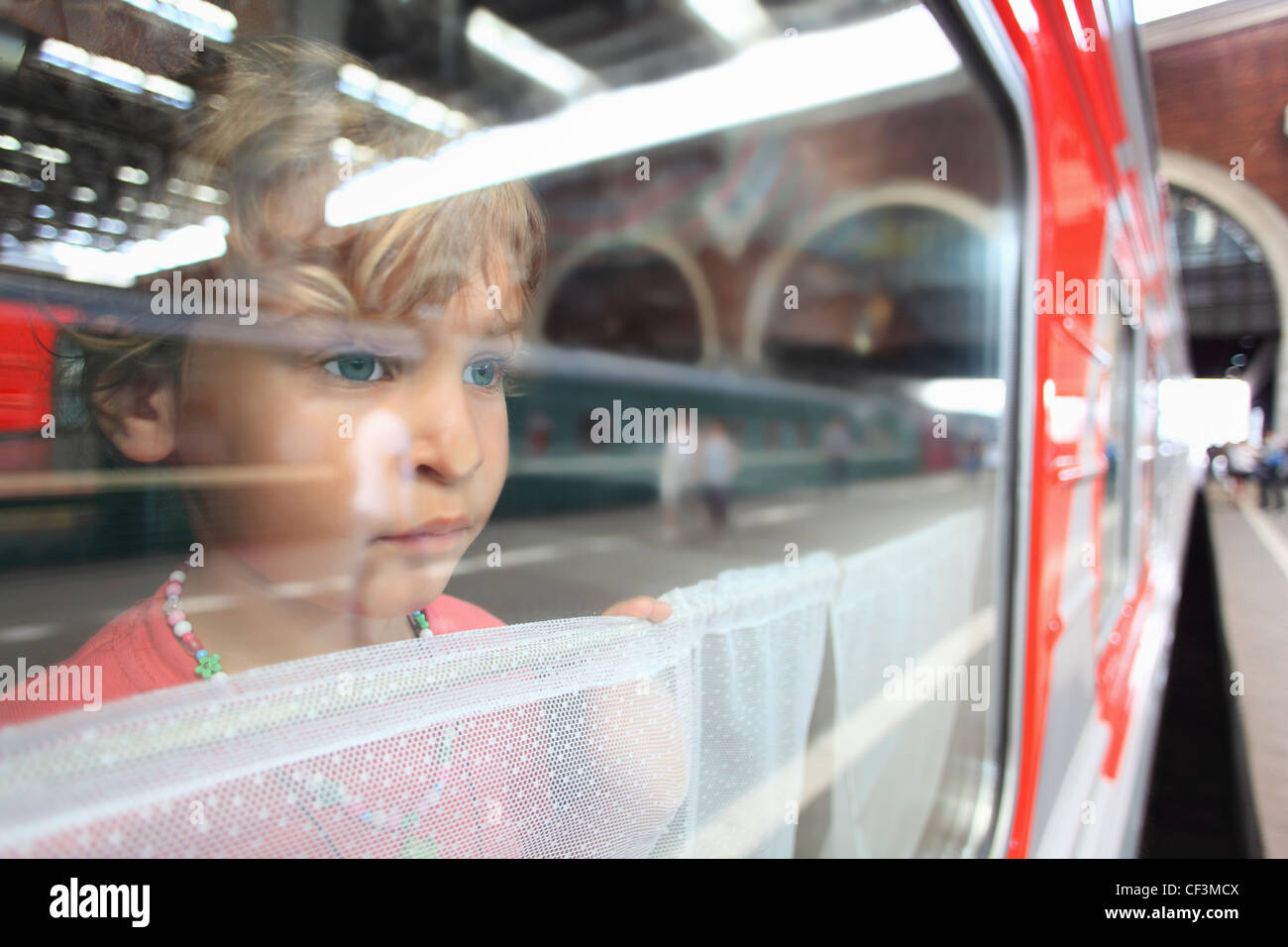 Bambina guardare dalla finestra del treno Foto Stock