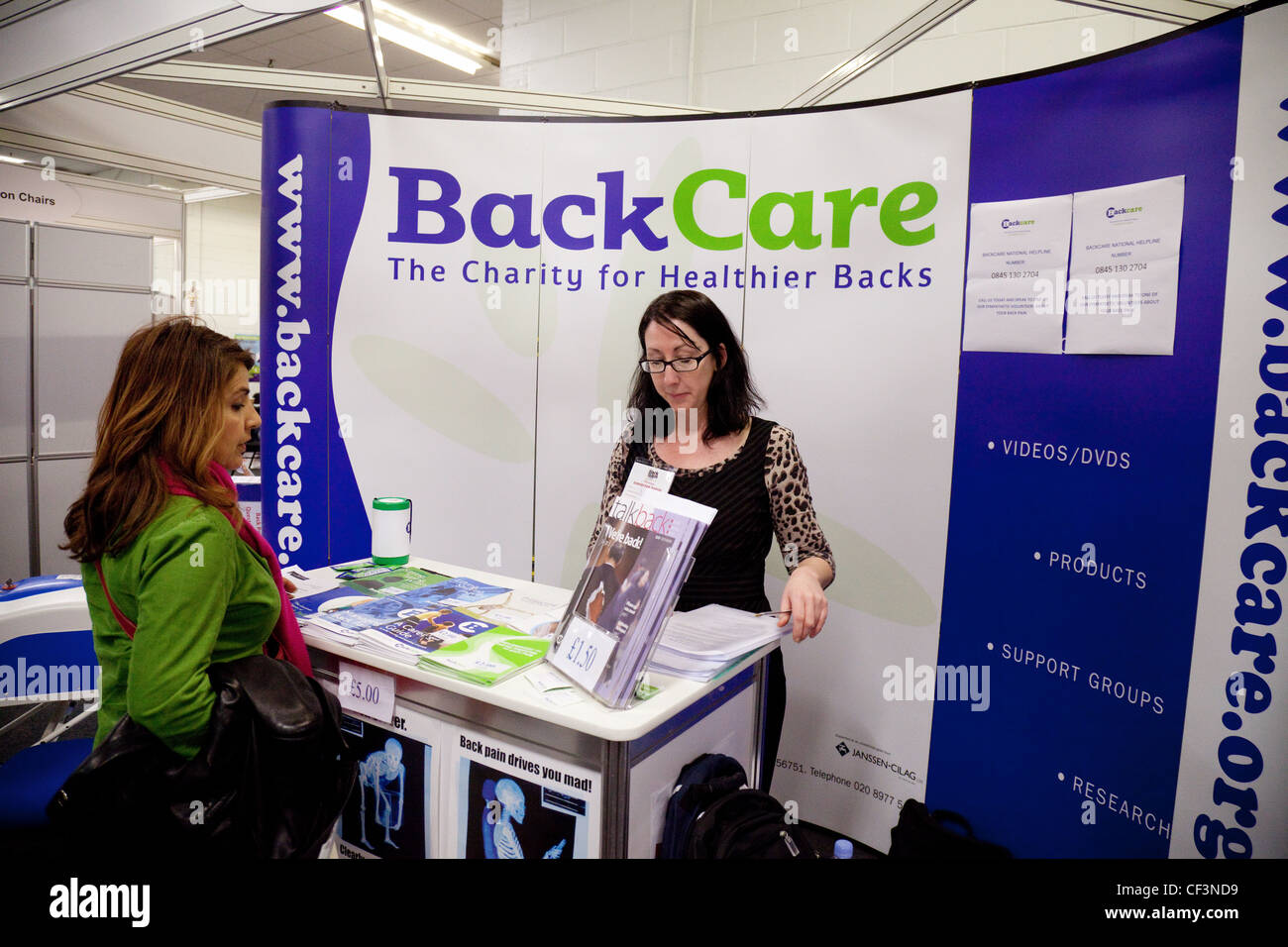 Una donna di consultazione della carità BackCare stallo a il dolore alla schiena show, London REGNO UNITO Foto Stock