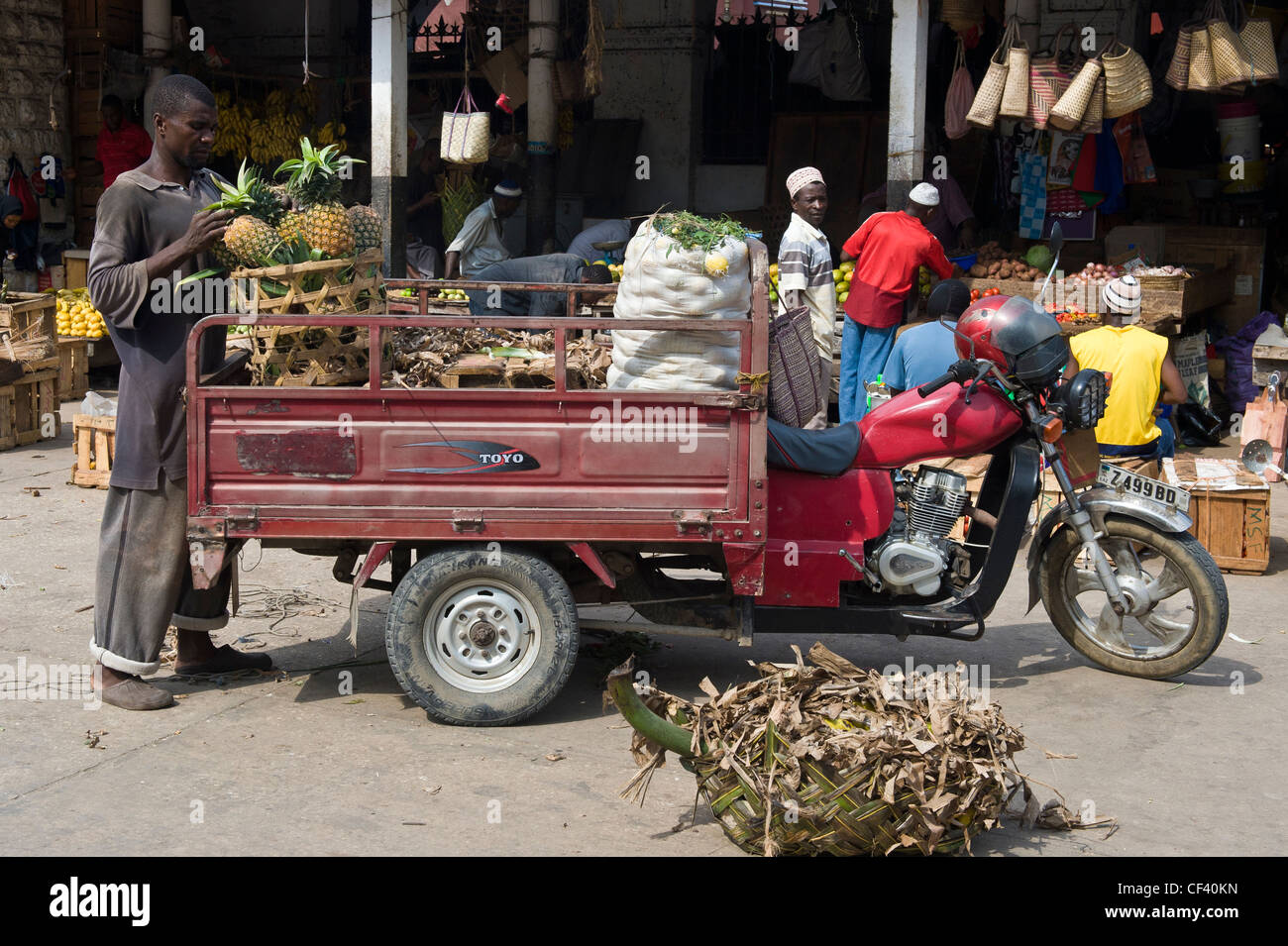 Agricoltore offre ananassi con un tuk-tuk al mercato di Stone Town Zanzibar Tanzania Foto Stock