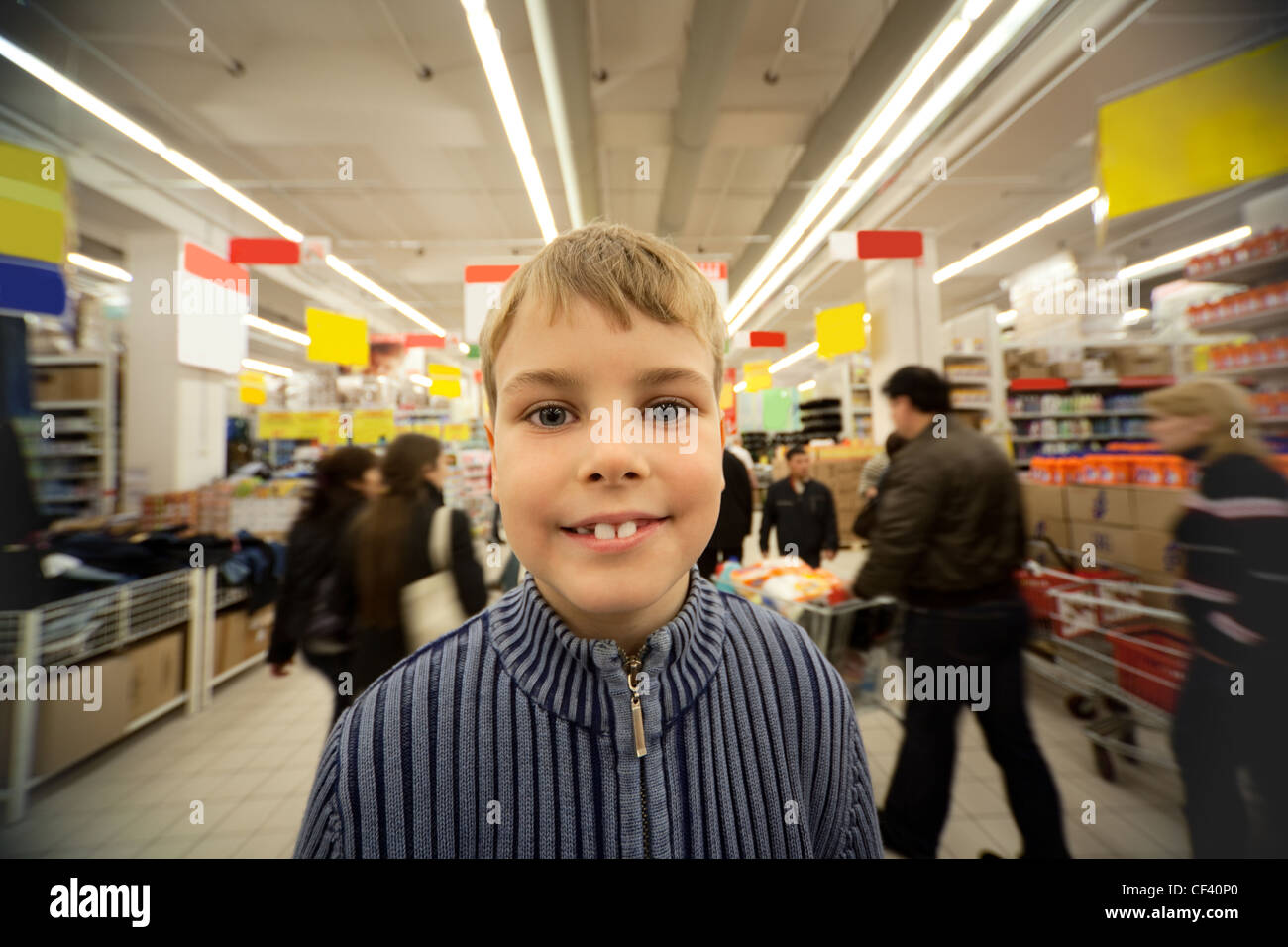 Ragazzo Smilling stand nel centro di trading floor nel supermercato Foto Stock