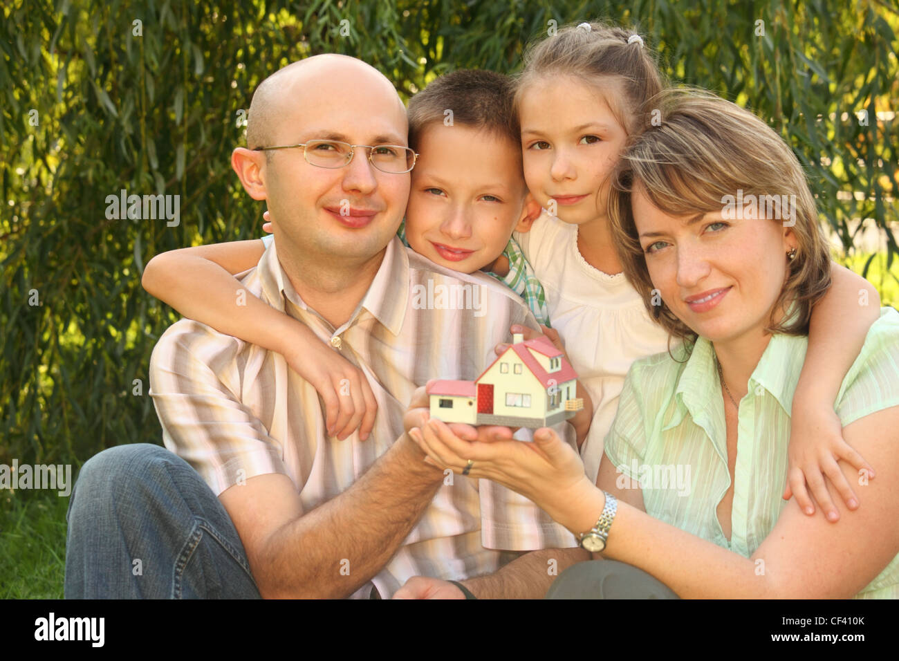 Famiglia con due bambini mantenendo wendy house nelle loro mani Foto Stock
