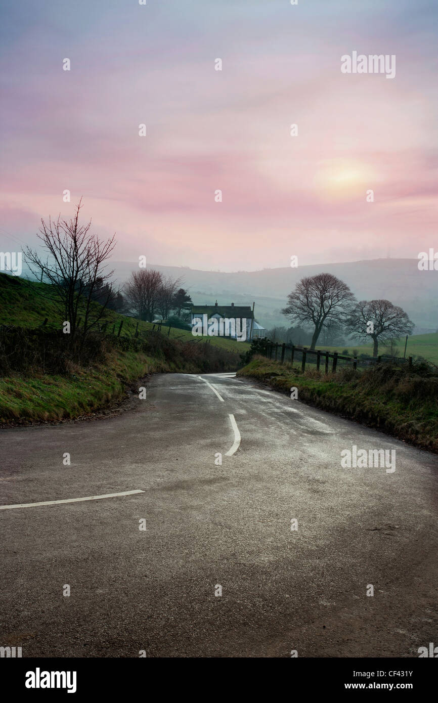 Una strada di campagna che attraversa il cuore rurale del Cheshire in una nebbiosa giornata invernale e. Foto Stock