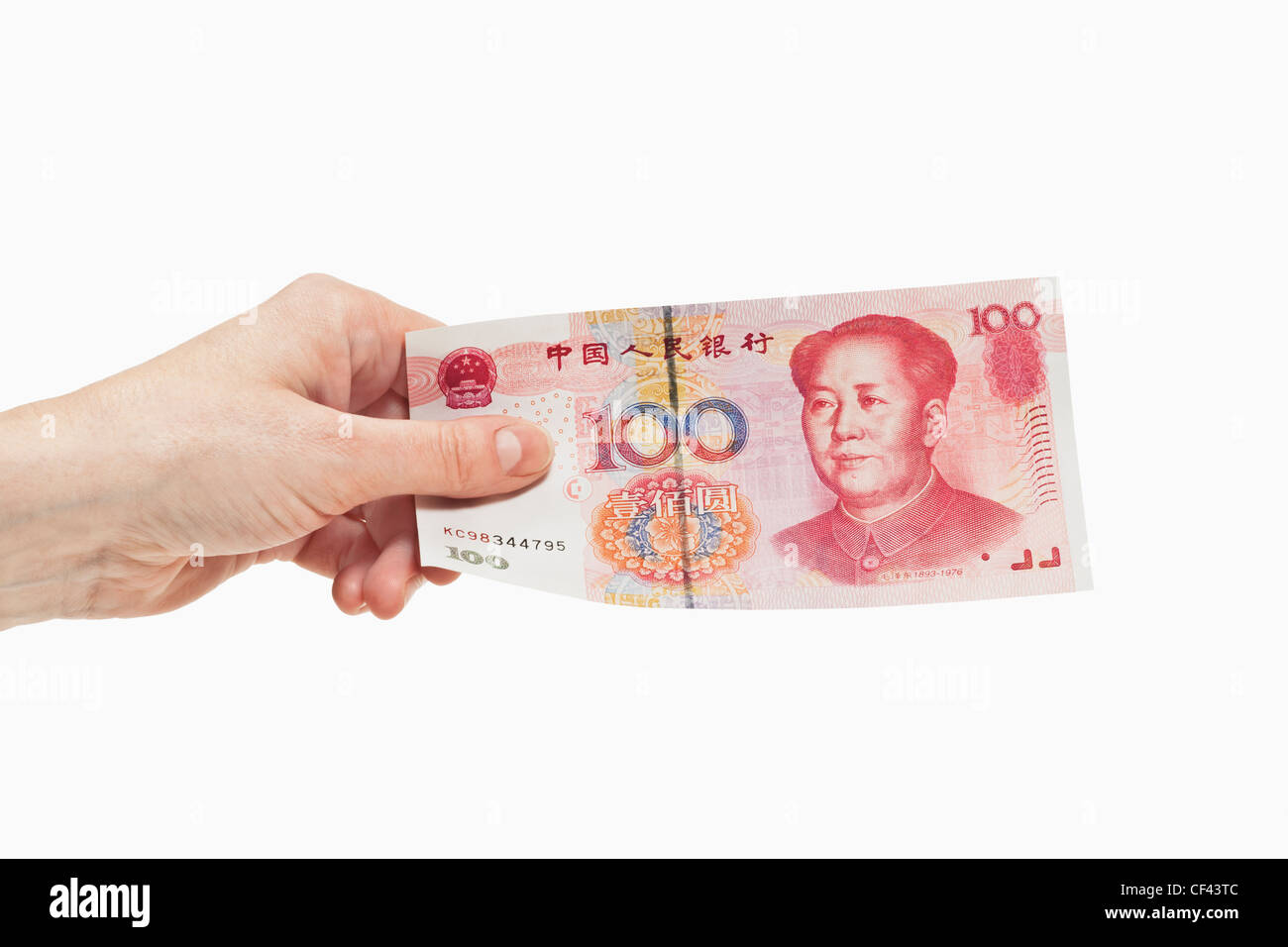 Uno cinese 100 Yuan bill con il ritratto di Mao Zedong è tenuto in mano, sfondo bianco. Foto Stock