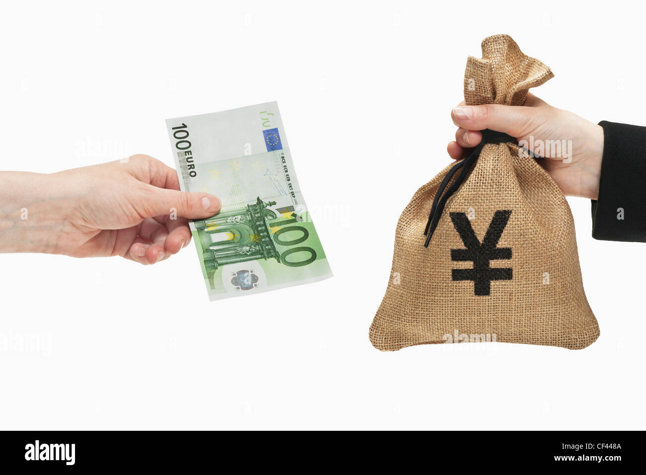 Un Euro 100 bill è tenuto in mano. Dall'altro lato un sacco di denaro con un Yen giapponese simbolo della valuta è tenuto in mano. Foto Stock