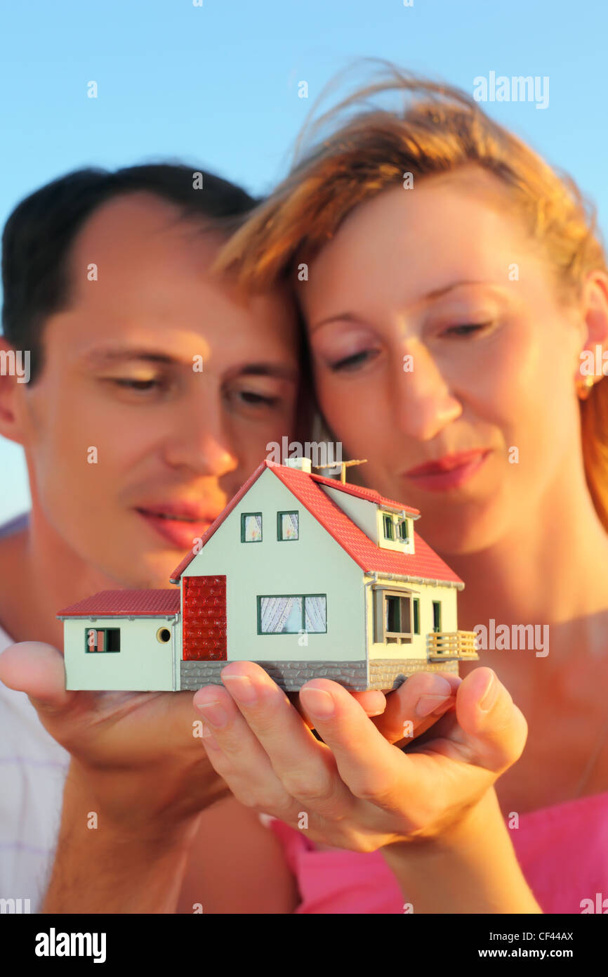 Giovane donna e uomo mantenendo in mani modello di casa Foto Stock