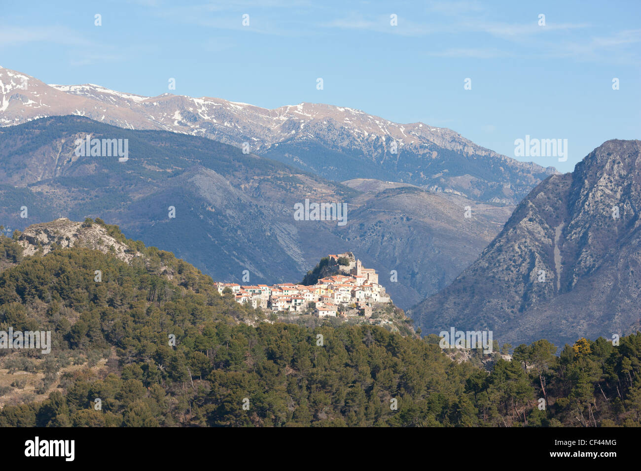 VISTA AEREA. Borgo medievale in cima alla collina di Piene-Haute con le Alpi meridionali sullo sfondo. Il backcountry della Costa Azzurra, Francia. Foto Stock
