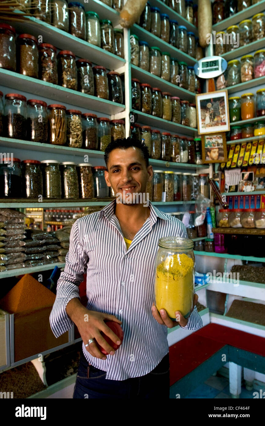 Un locale spice shop proprietario in piedi con un barattolo di spezie nel suo negozio in Djemaa el Fna mercato in Marrakech Marocco Foto Stock