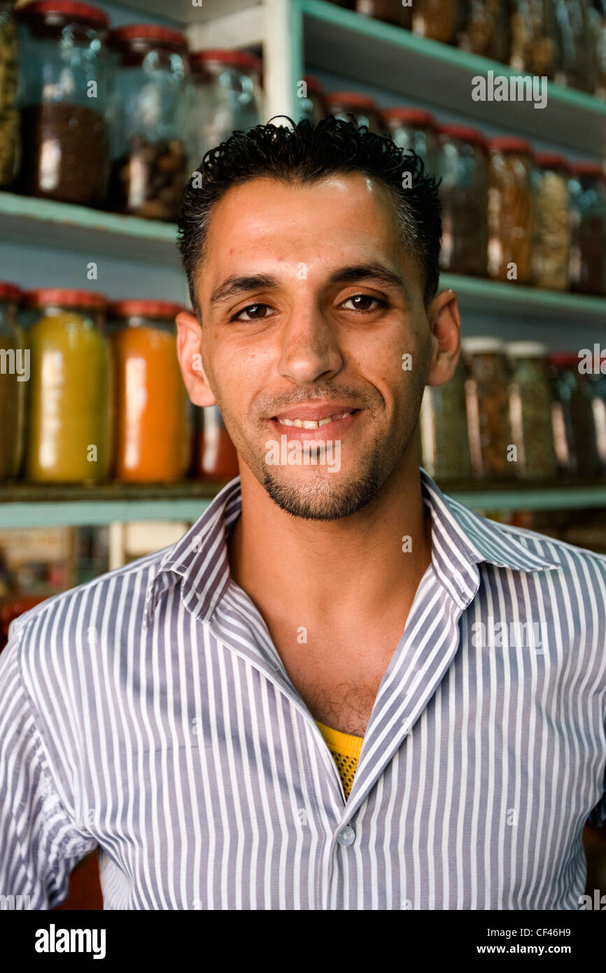 Un giovane locale proprietario del negozio nel suo tradizionale negozio di spezie in Djemaa el Fna mercato in Marrakech Marocco Foto Stock