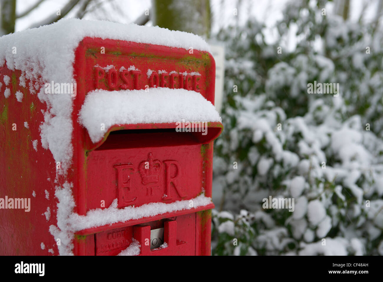 La neve copre un tradizionale rurale britannica post box in Essex. Foto Stock