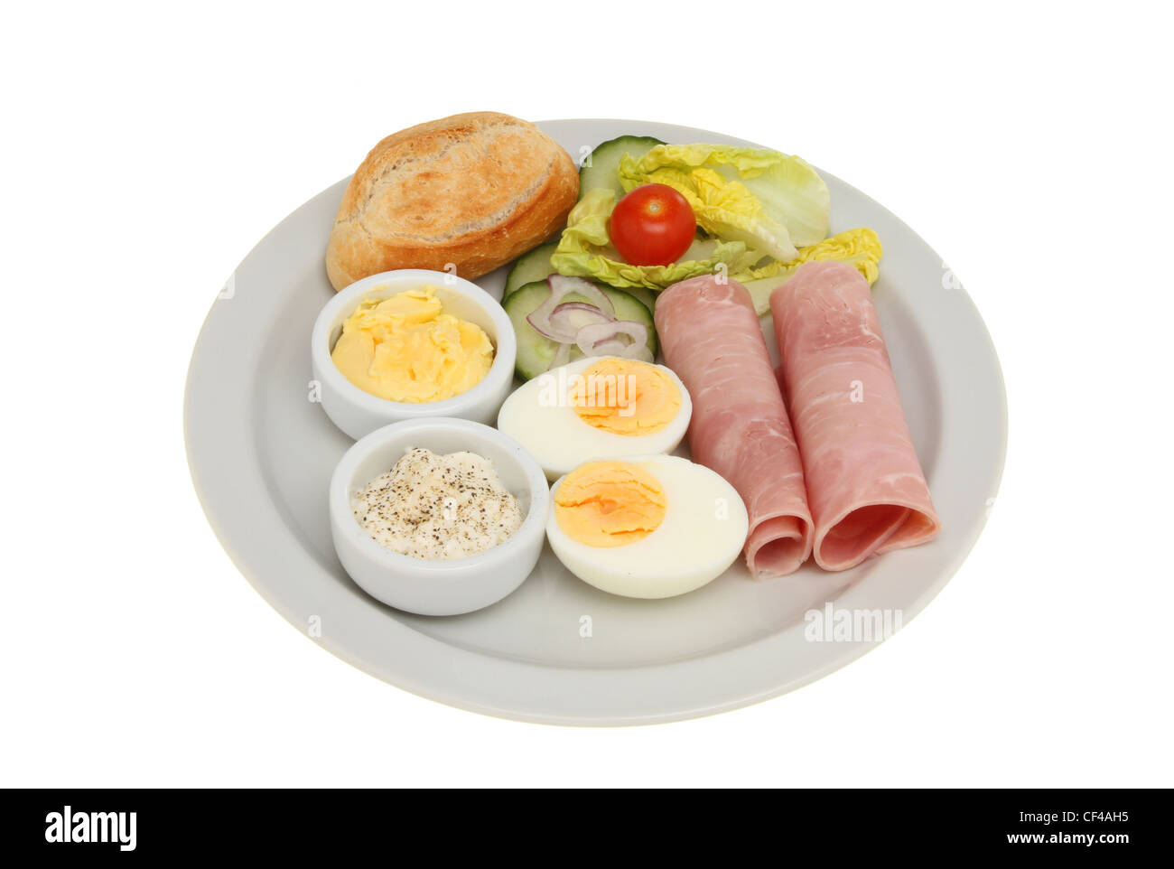 Prosciutto e insalata di uova con un pane petit dolore pane, burro e maionese su una piastra isolata contro bianco Foto Stock