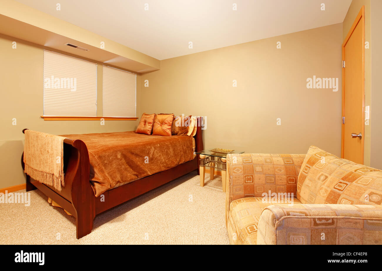 Livello giardino semplice valutazione camera da letto con un letto singolo  e una grande poltrona con pareti di colore verde Foto stock - Alamy