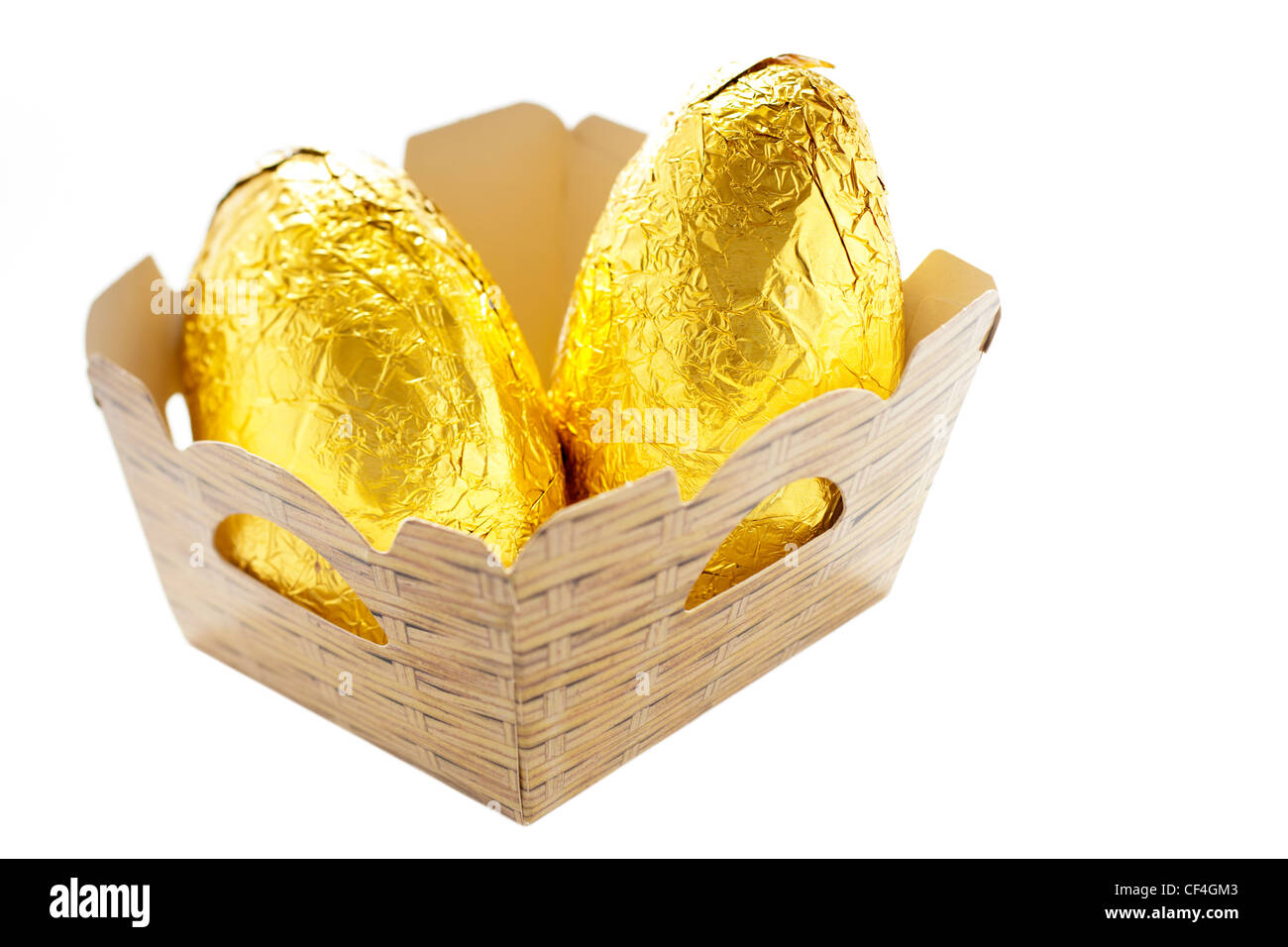 Due di lamina di oro più semplice di cioccolato uova in una cestella di cartone Foto Stock
