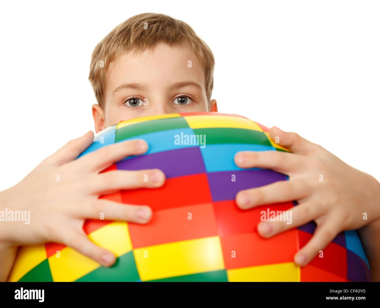 Ragazzo tiene di fronte a sé grandi, multicolore e pallone gonfiabile, guardando fuori da dietro di esso. Guarda nella telecamera. Foto Stock