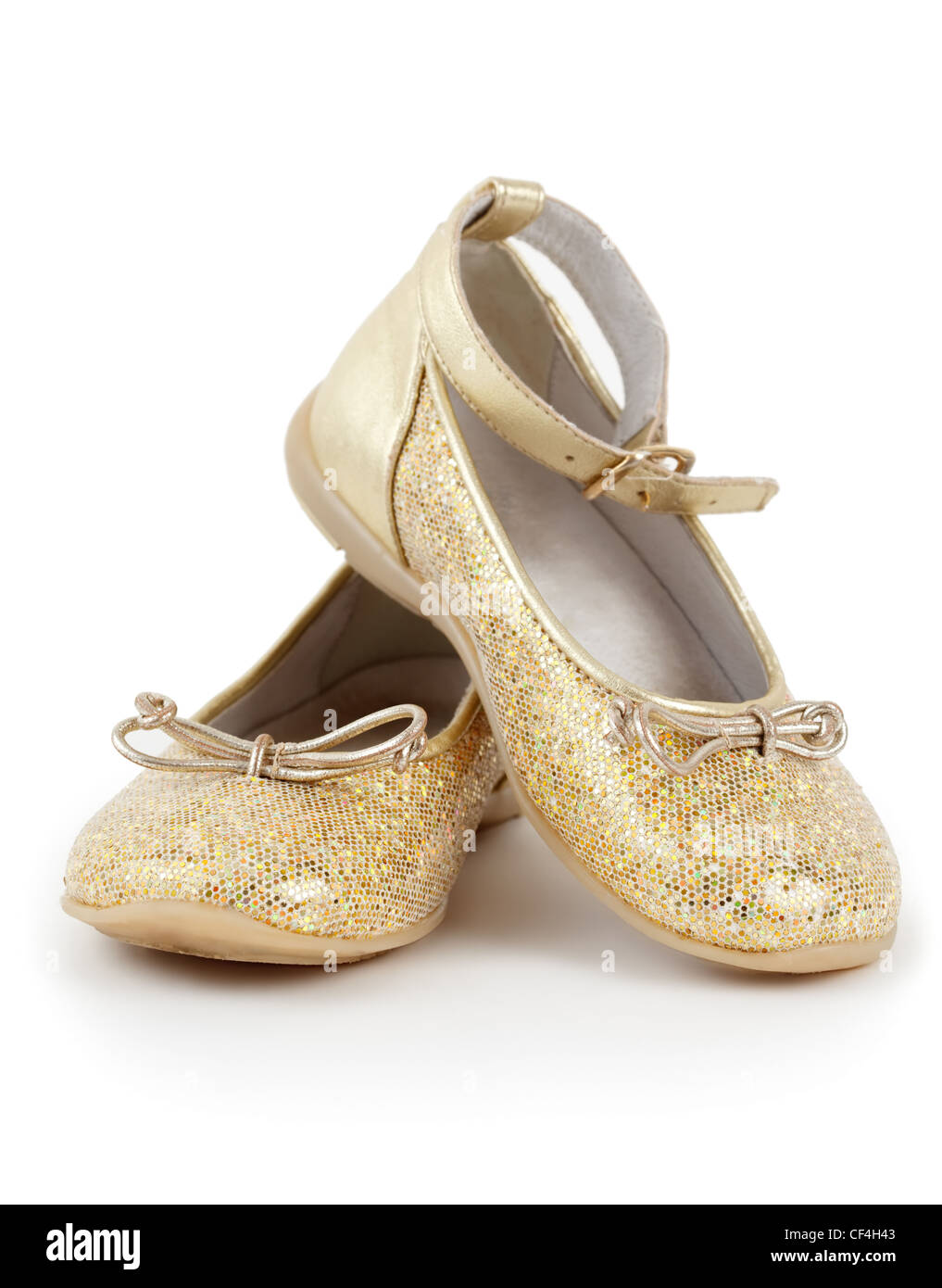 Coppia di shiny golden scarpe per ragazze su sfondo bianco. Foto Stock