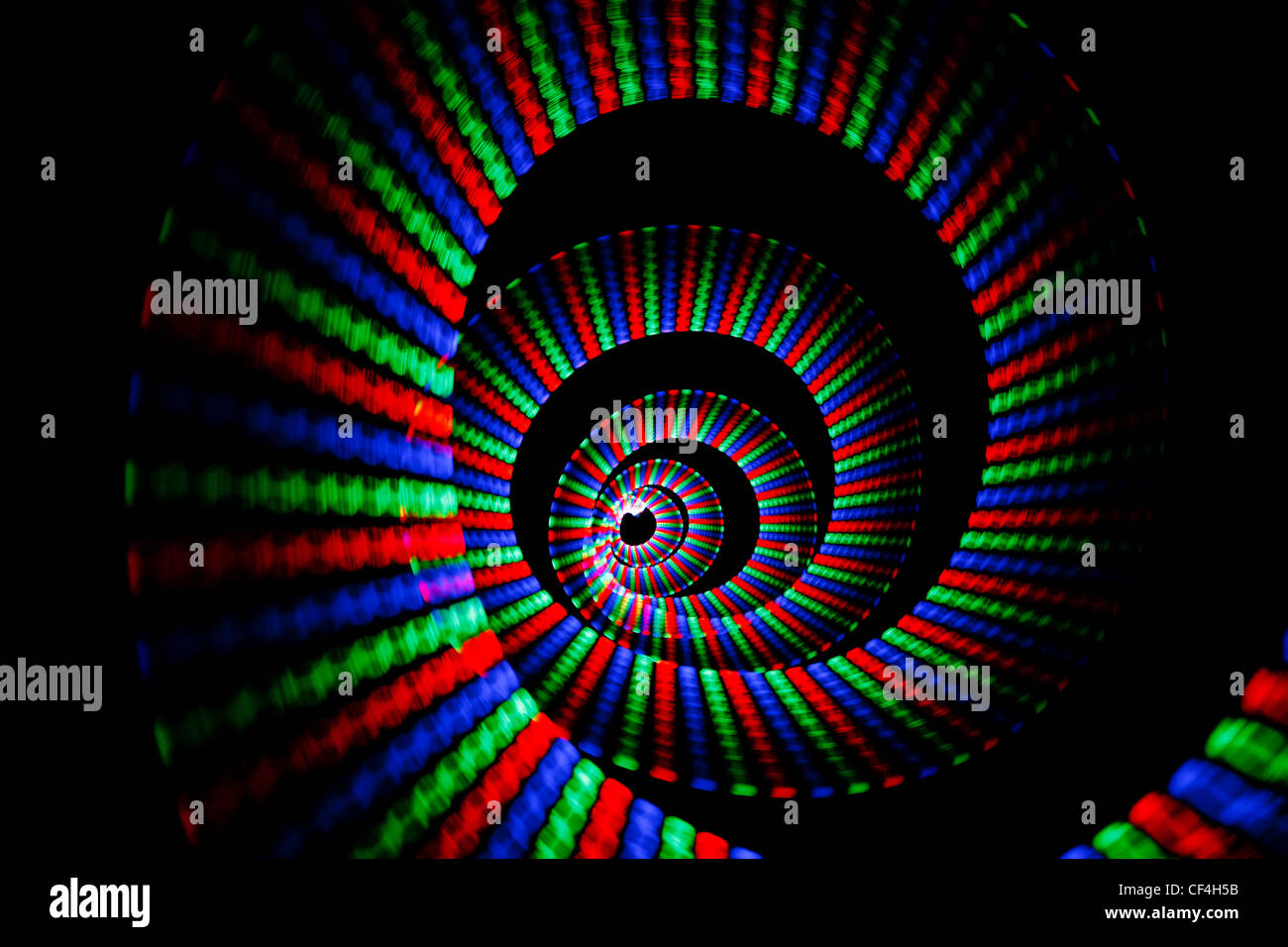 Colori luminosi di rainbow trail in forma di spirale su sfondo nero. Isolato. Foto Stock
