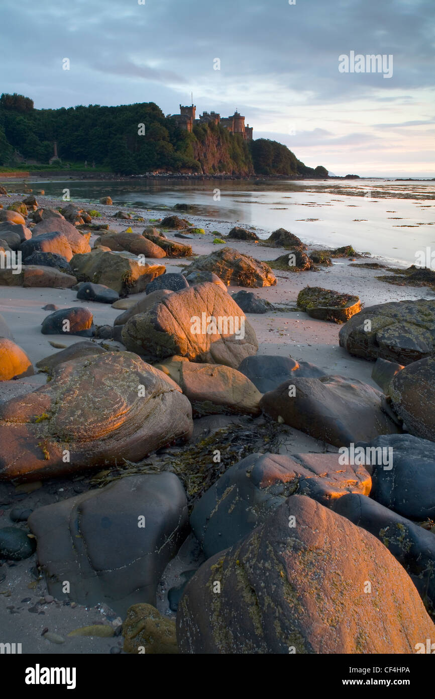 Una vista sulla spiaggia verso Culzean Castle. Robert Adam il castello, costruito 1772-1790 per David, decimo conte di Cassillis su un clifft Foto Stock