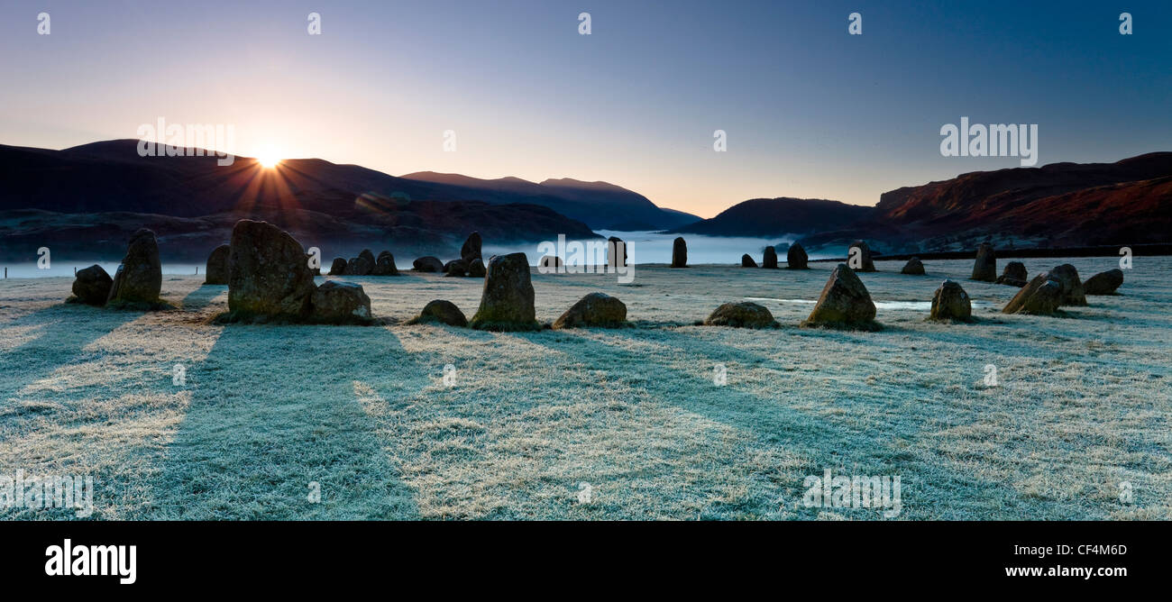 Il Castlerigg Stone Circle su un gelido mattina come i primi raggi di luce appaiono sulle colline nel distretto del lago. Foto Stock