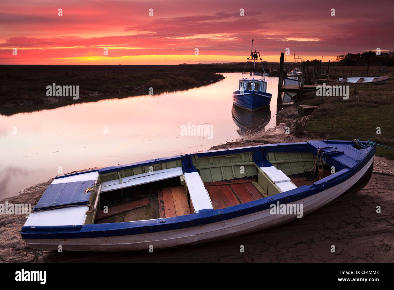 Piccole imbarcazioni ormeggiate nel porto di Thornham a sunrise. Foto Stock