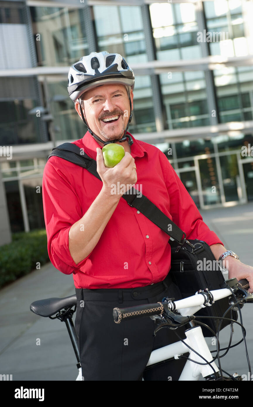 In Germania, in Baviera, uomo maturo in bicicletta con frutta, ritratto, sorridente Foto Stock