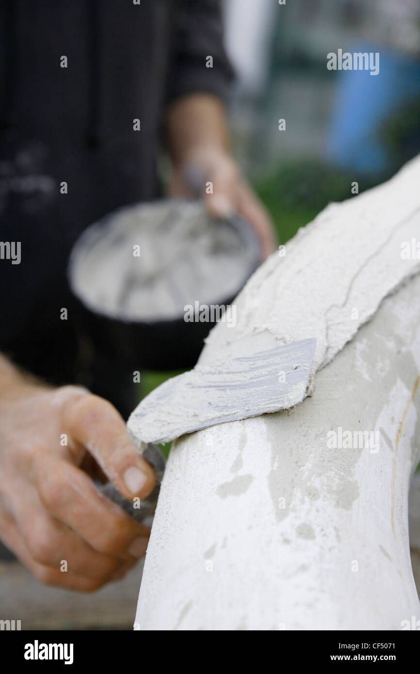 In Germania, in Baviera, Monaco di Baviera, Schaeftlarn, scultore applicando un intonaco con cazzuola Foto Stock