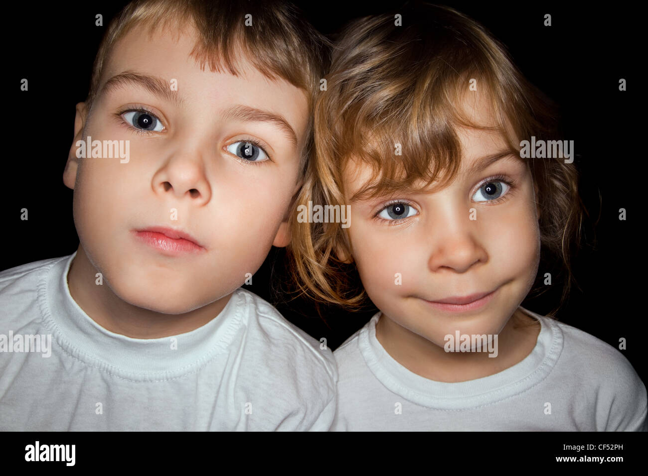 Bambino e bambina in bianco T-shirts isolati su sfondo nero Foto Stock