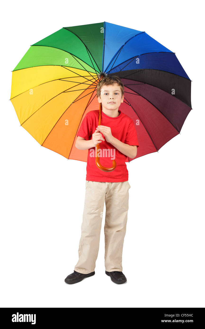 Little Boy in maglietta rossa con grande ombrello multicolore in piedi su bianco Foto Stock