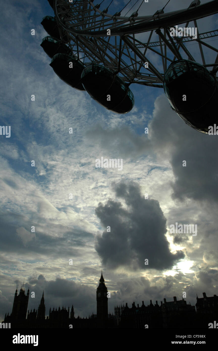 Sagome del London Eye e le case del Parlamento contro una drammatica del cielo della sera. Foto Stock