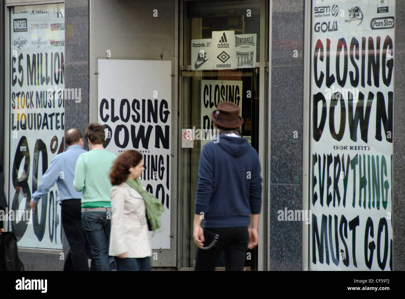 Gli amanti dello shopping che passa in un negozio la pubblicità di una chiusura in vendita in Oxford Street. Foto Stock