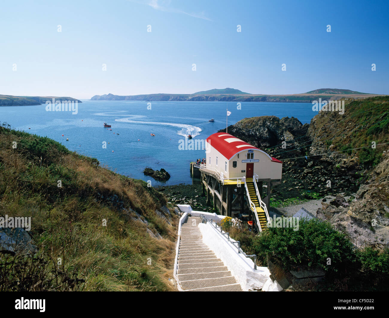 Una nave passeggeri ritorna dal Ramsey isola per l'ancoraggio di Porthstinian. Impazzano le scale conducono la scogliera a San Giustiniano Foto Stock