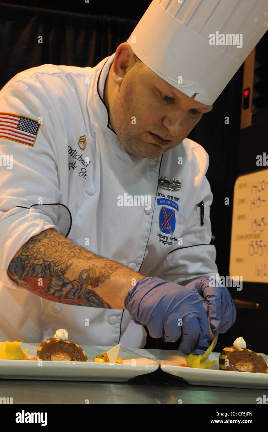 Esercito degli Stati Uniti Sgt. Michael Bogle con la squadra culinaria di Fort Drum fissa le piastre durante la sfida di Pasticceria in tensione a Fort Lee, Virginia, 29 febbraio 2012. Tutte le filiali militari hanno gareggiato in diverse categorie durante il 37° concorso culinario militare annuale. Foto Stock