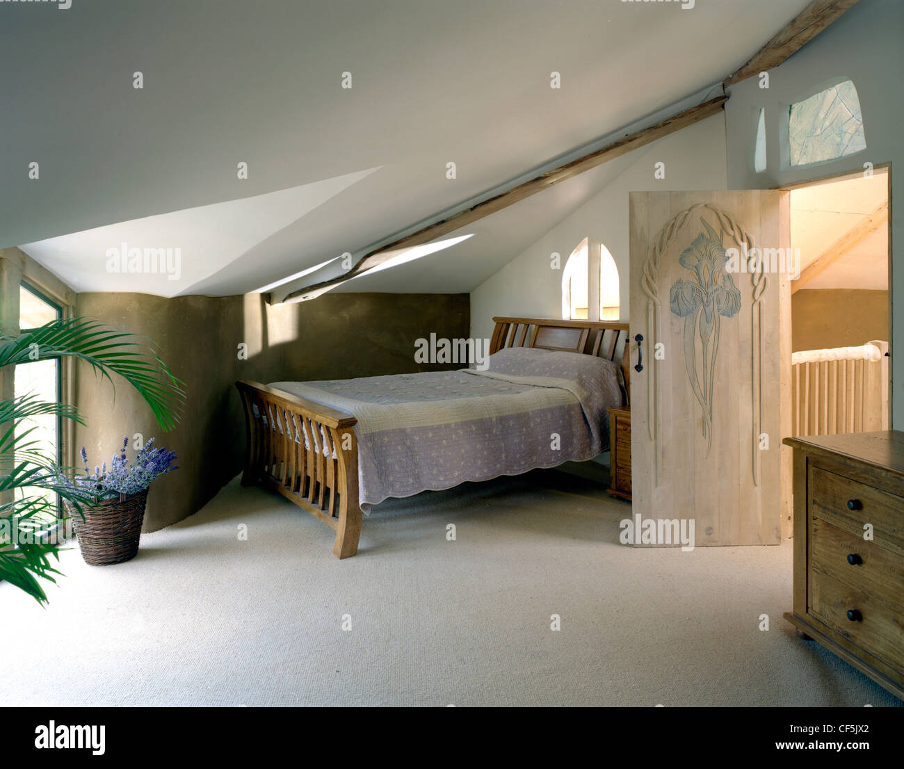 Il interiof a due piani Eco casa in Cambridgeshire Fens, UK, mostra camera da letto letto in legno e cassettiera, tappeto Foto Stock
