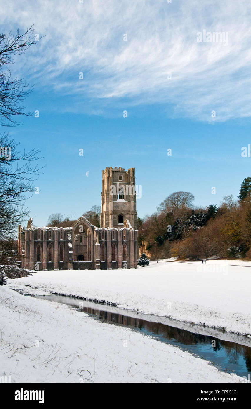 La neve che copre il terreno intorno al XII secolo le rovine di Fountains Abbey, il più grande rovine monastiche in Inghilterra. Foto Stock