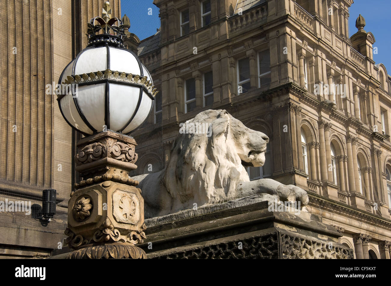 Un leone scolpito su un plinto e lampada ornata al di fuori di Leeds Town Hall sul Headrow, la strada principale di Leeds City Centre. Foto Stock