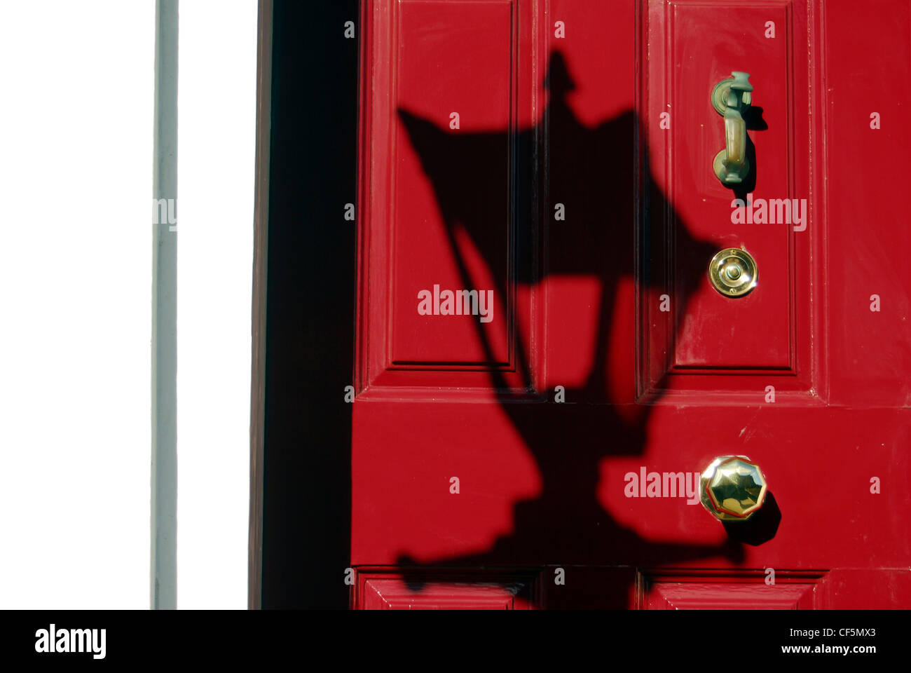 L ombra di una lampada su una porta rossa nel centro di Dublino. Foto Stock