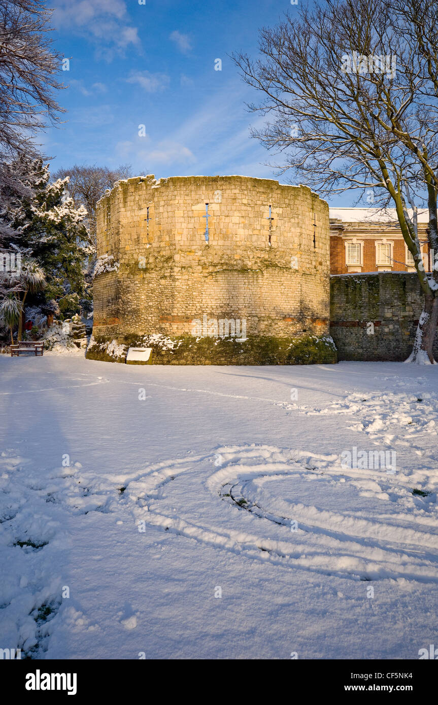 La coperta di neve-romana costruita Torre Multangular nel Yorkshire Museo giardini nel centro di York. Foto Stock