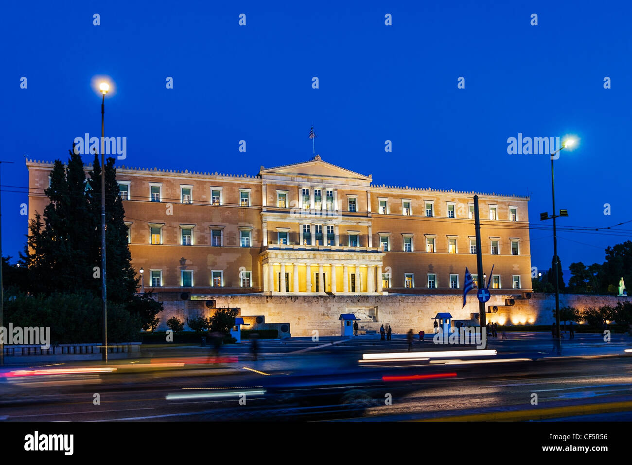 Il palazzo del parlamento, Atene, Grecia, nella foto di notte con faro e striature di luce di posizione posteriore dal passaggio di auto e veicoli Foto Stock