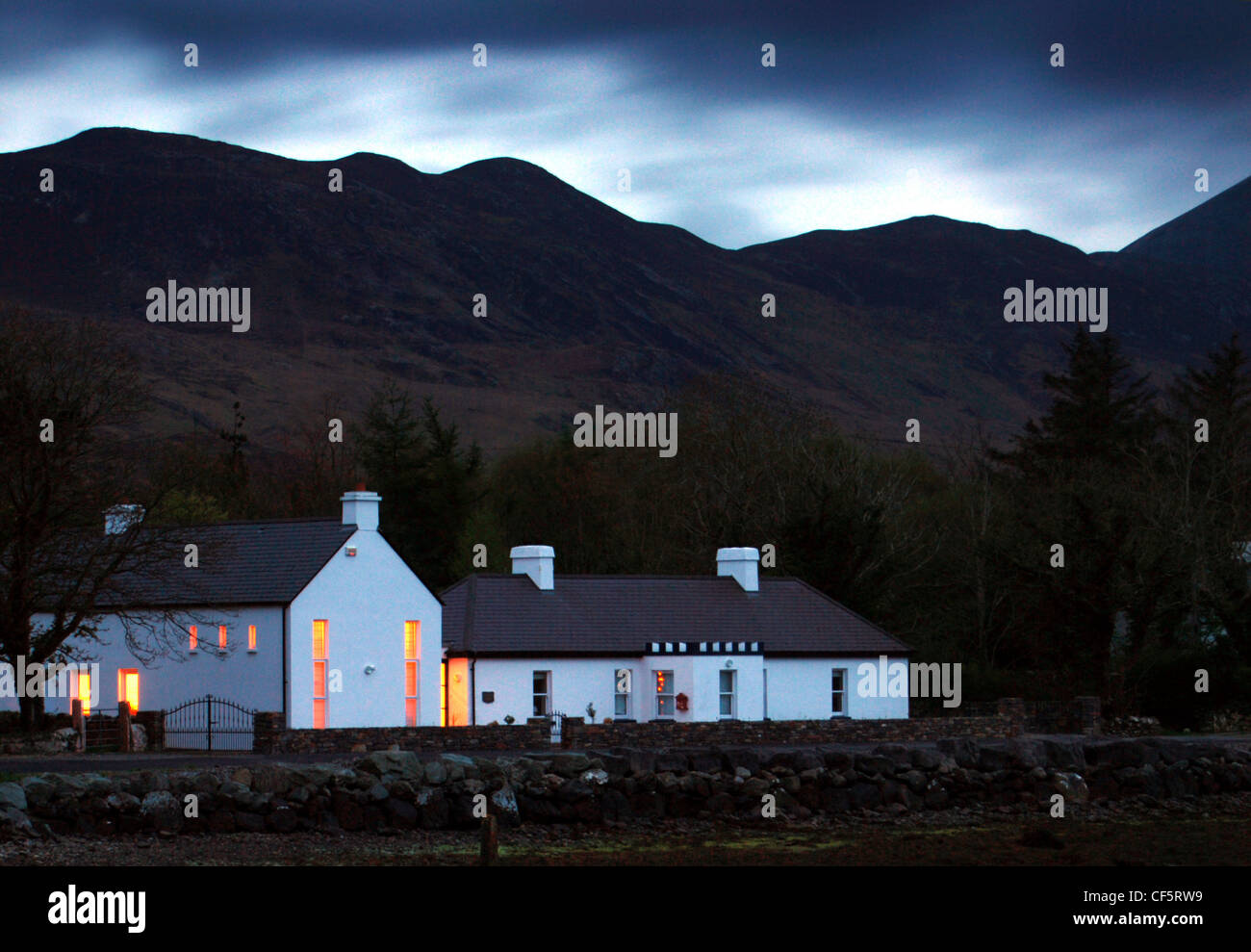 Case al tramonto con uno sfondo montano vicino a Westport nella contea di Mayo. Foto Stock