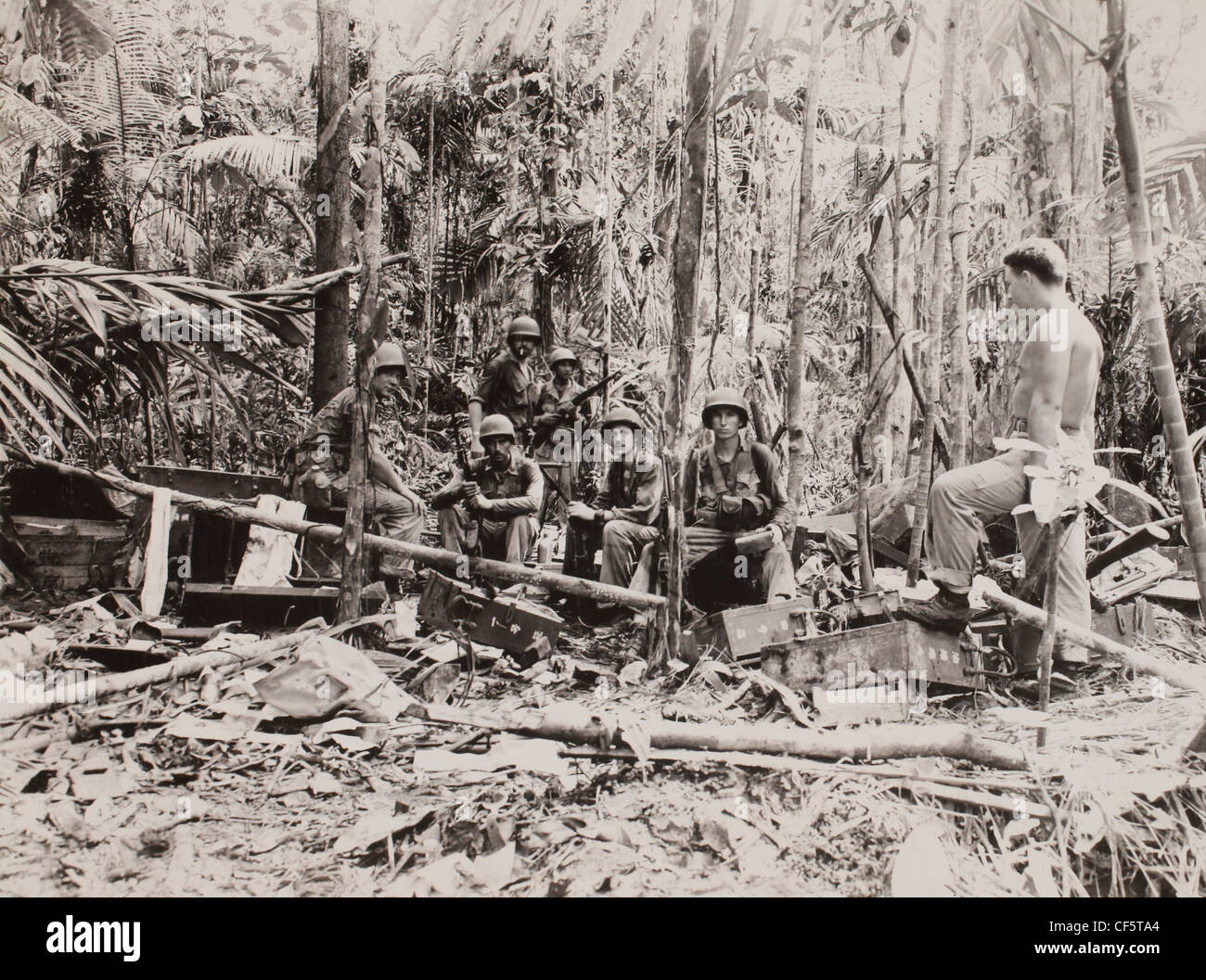 US Marine Corps WWII Pacific Campagna: Una pattuglia di marine entra in pausa per un breve periodo di riposo e di posare per un fotografo in un catturato Japa Foto Stock