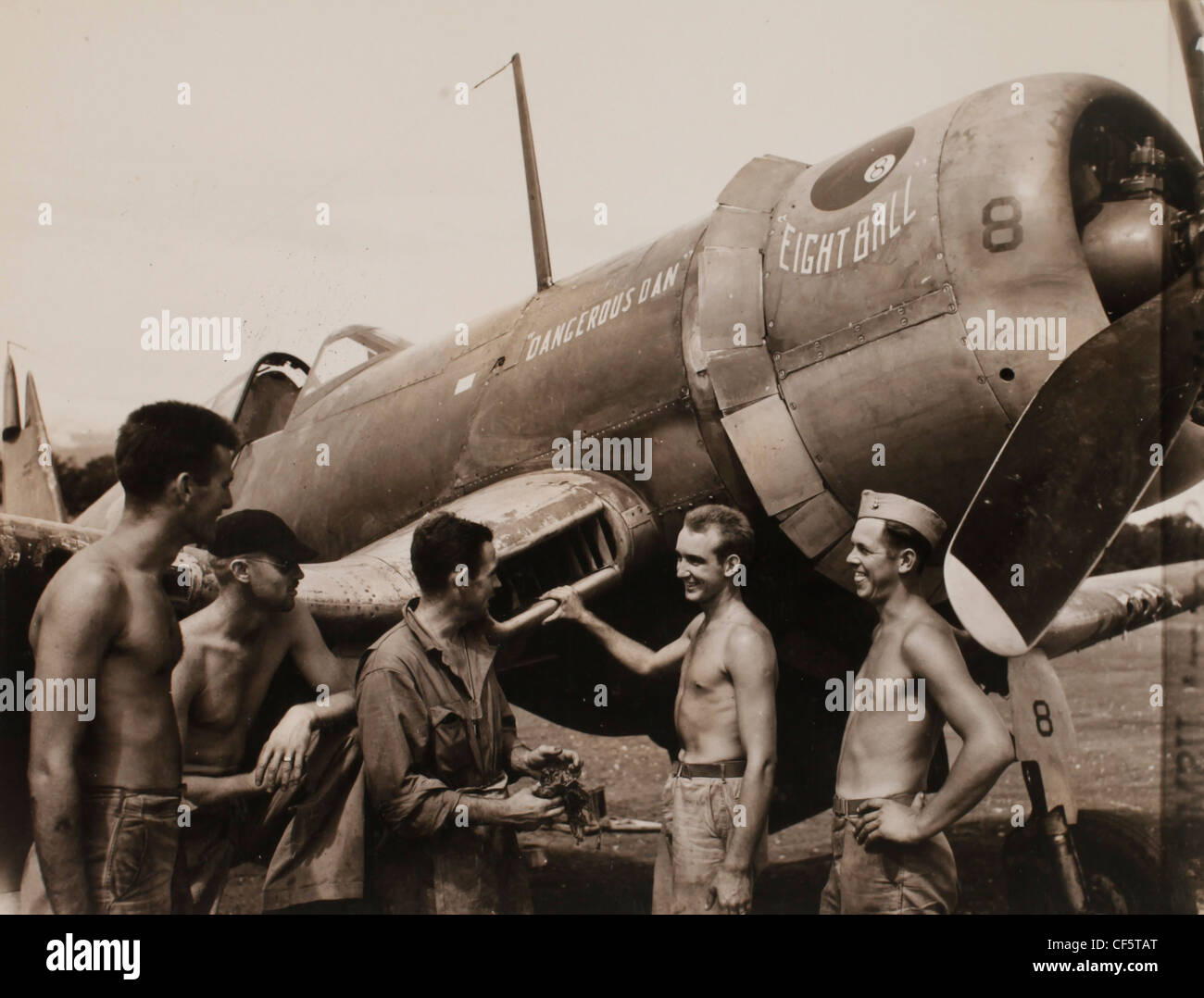 US Marine Corps WWII Pacific campagna: in un momento di ricambio diversi della meccanica stand intorno e 'Shoot la brezza' tutti durante Foto Stock