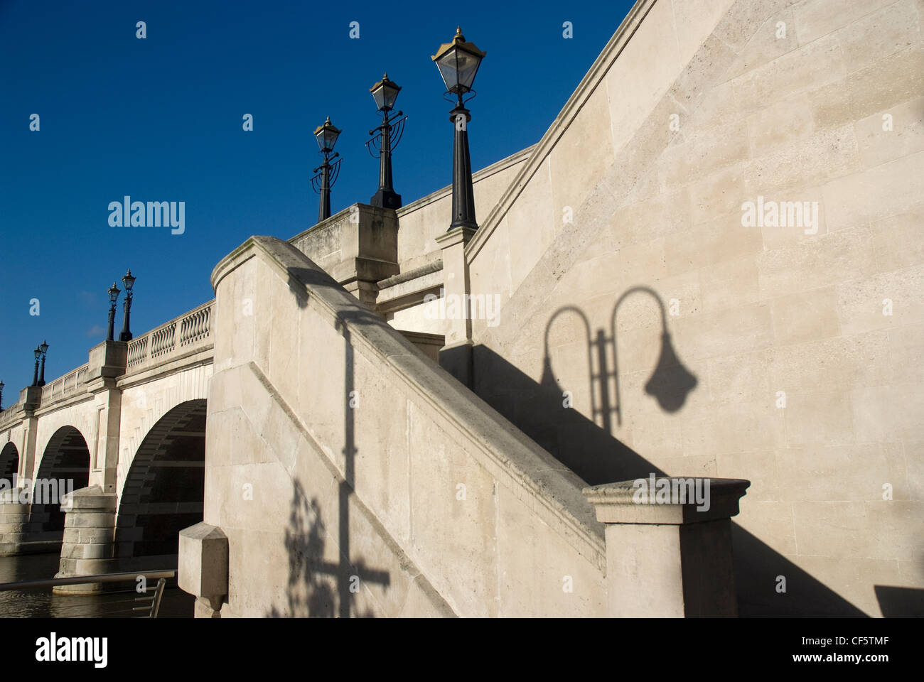 L'ombra di una vecchia strada lampada sulla muratura in pietra dalla scalinata che conduce al Kingston Bridge. Foto Stock