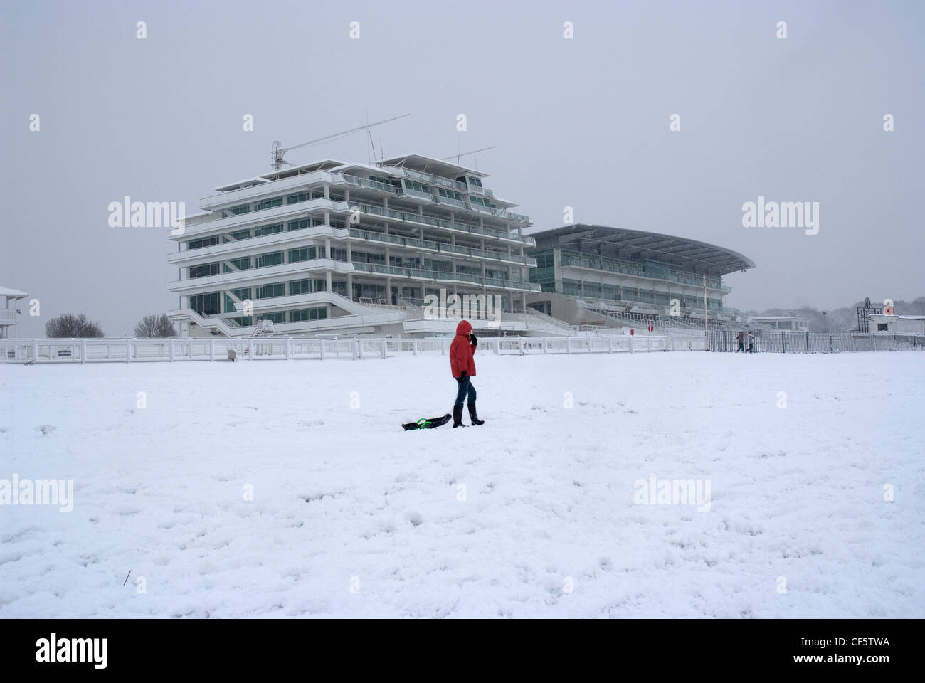 Persone con slitte cercando una buona pendenza a Epsom Racecourse. Foto Stock