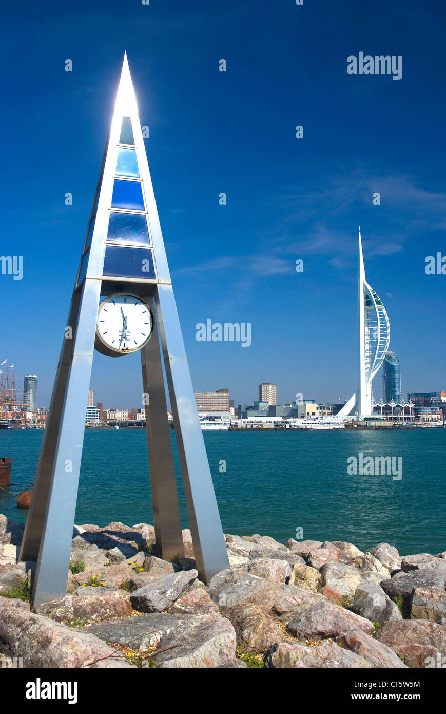 Un contemporaneo orologio scultoreo sul lungomare a Gosport opposta 170m alto Spinnaker Tower al Gunwharf Quays. Foto Stock