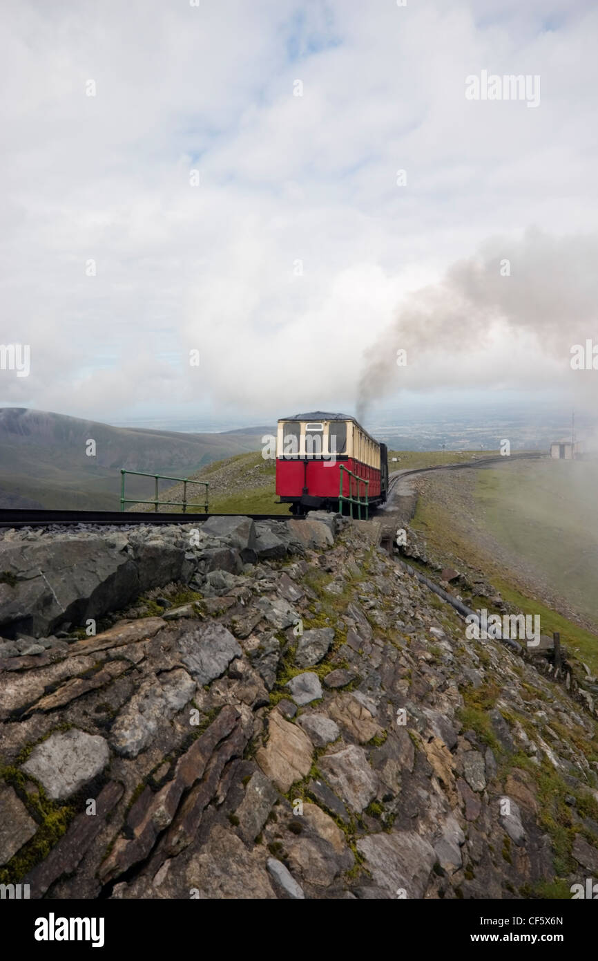 Un Snowdon Mountain railway treno a vapore scalare una montagna su Snowdon. È da più di cento anni di età ed è il solo pubblici ferrovia a cremagliera Foto Stock