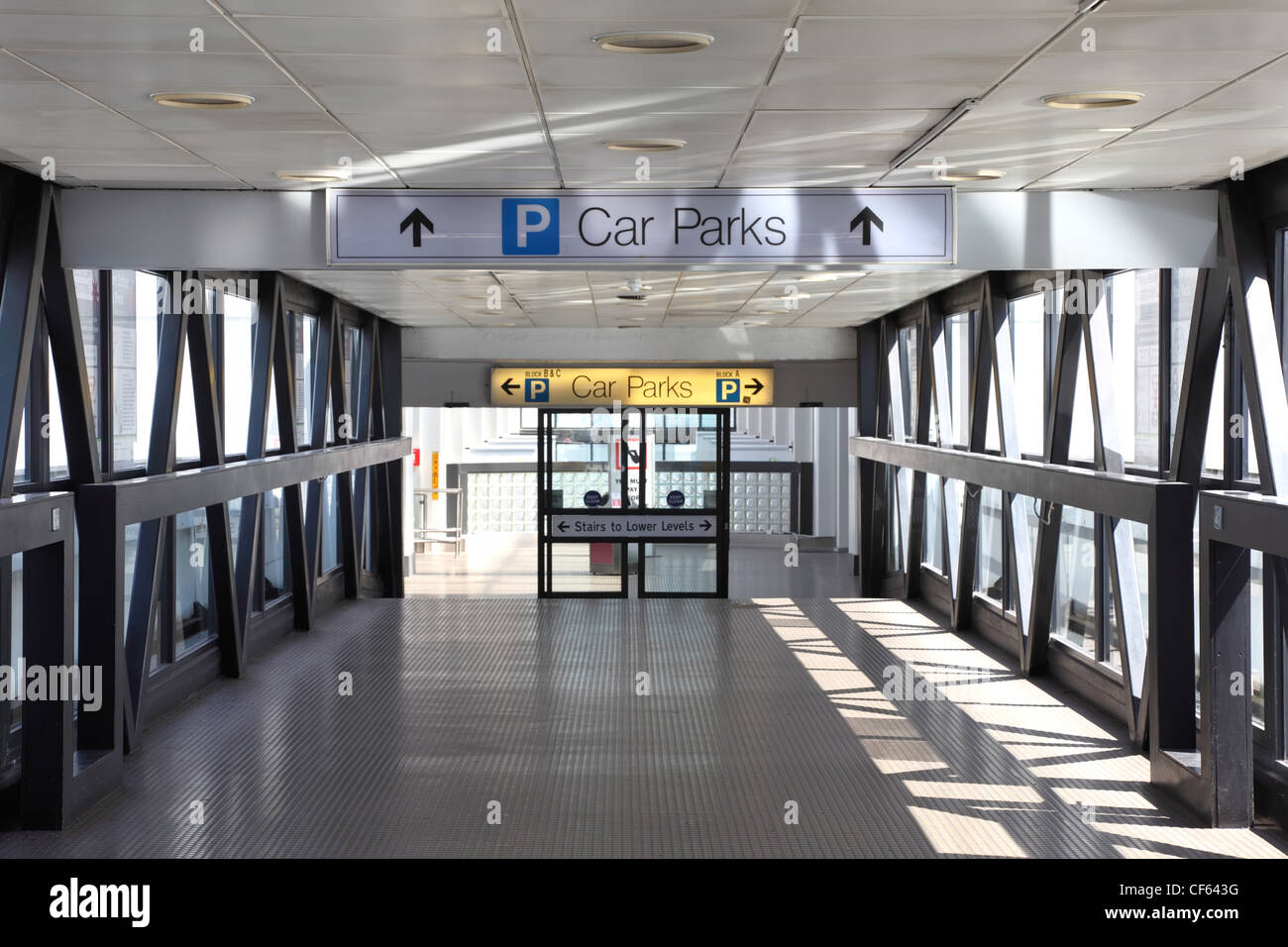 Ingresso al parcheggio. Porte di vetro, la luce del sole splende attraverso grandi finestre Foto Stock